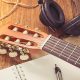 A Display Of Guitar, Headphones & A Booknote For Music Learning.