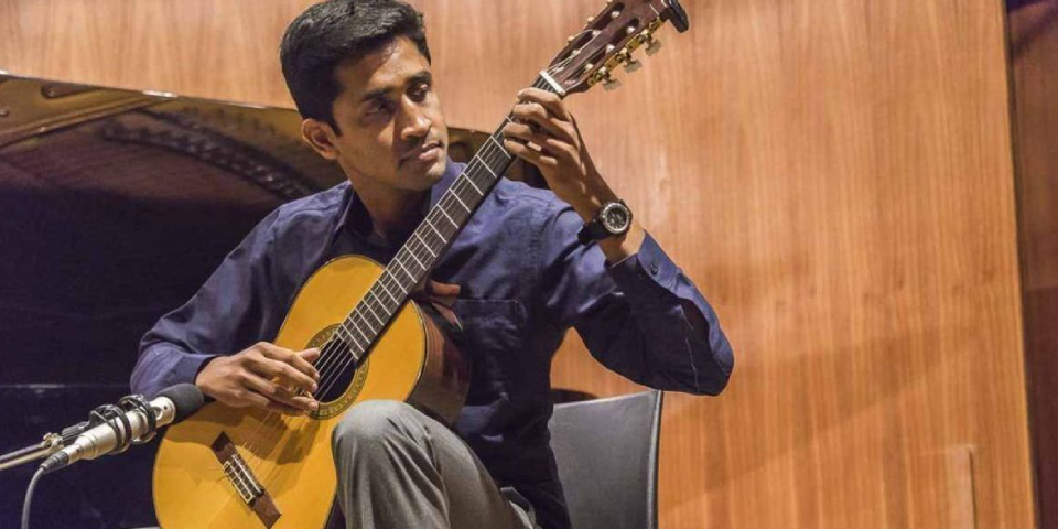 An Indian Musician Changing The Chords While Playing Guitar.
