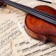 Collection of Musical Notes & papers Placed On The Table With Violin.